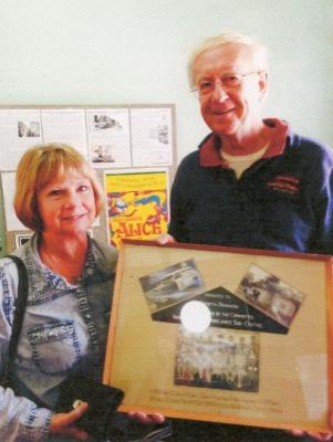 Kerry Cockburns - Campbell granddaughter of Kenneth Johnson presenting to Charles Gilbert the large framed set of three photographs from the St. John Ambulance sub - centre.