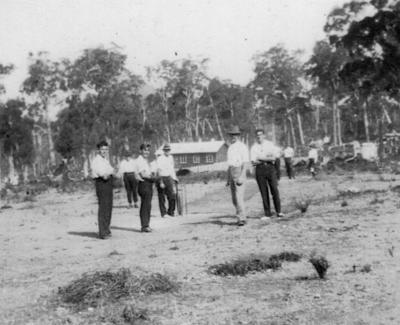 Men playing cricket at Ellis Creek school