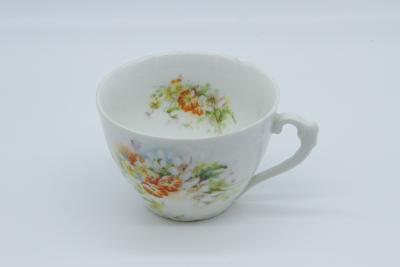 CUP, CHIPPED WITH WHITE ORANGE FLOWERS