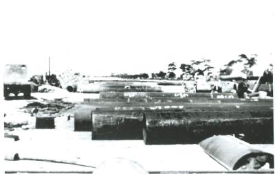 Black and White photograph Electweld Pipe ready for cement lining Machinery in the background