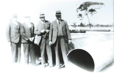 Black and White photograph Frank Mather and government inspectors and finished pipes