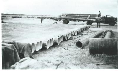 Black and White photograph.  New cement lined pipes manufactured by Electweld steel co Kellerberrin