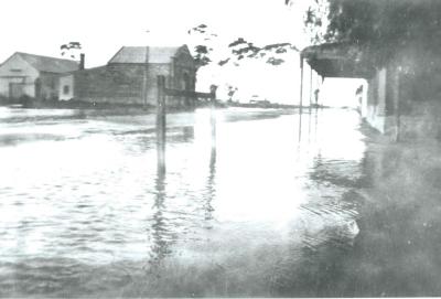 Black and White photograph.  Kellerberrin Fire Station across the road from Hotel corner during flooding