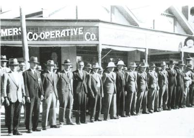 Black and White photograph.  Men lined up along Massingham Street watching ANZAC parade