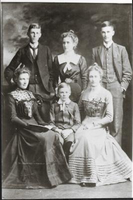 Black and White photograph.  Family of Robert Buck and Jane Leake Back left:  Hubert Leake, Hilda Leake, Bruce W Leake. Seated left : Amy Leake, Harry Leake and Mary Leake
