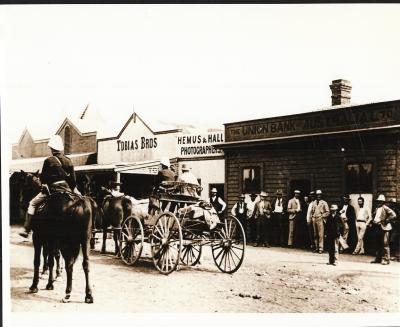 Black and White photograph.  Street in Cue showing Tobias Bros, Hemus and Hall photographers and the Union Bank of Australia