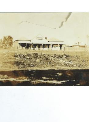 Black and White photograph.  Lowe's store 1926.  Drapery, General Store, Mrs Young's Fruiterer and Post Office Situated at rear of Doodlakine Co-op Photo taken from site of Tiller's Butcher Shop