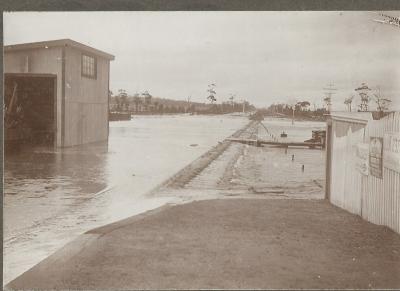 Black and White photograph of Doodlakine Railway Station showing flood water flowing across Railway tracks. 1915