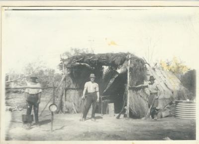 Black and white photograph.  3 men  outside a Humpy on Laird farm