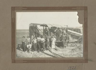 Black and white photograph.   Castledine's Chaff Cutter.  Bert Hartley with son Bill and dog Fluff. Archie Stubbs, cook with son. Jeff Franklin extreme left