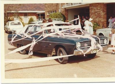 Colour photograph.  Wedding car decorated with toilet paper