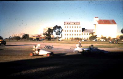 Slide showing TQ's racing on old Fire Brigade running Track.  Flour Mill in background