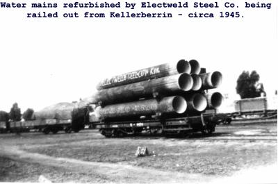 Black and White photograph.  Water Mains refurbished by Elecweld Co being railed out from Kellerberrin