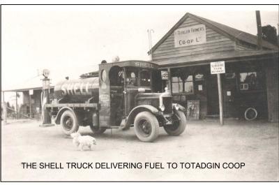 Black and White photograph.  Truck parked outside Totadjin Farmers Coop