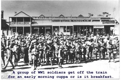 Black and White photograph.  A group of WWI soldiers get off the train for an early morning cuppa and breakfast