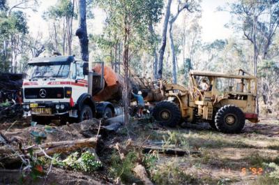 Mick Cockman lifting stanchion on log truck, while Les Cull holds the log with the loader.