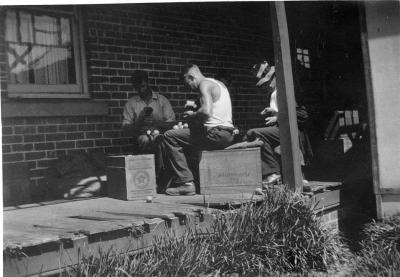 Wilkinson men brushing fruit on the Homestead verandah