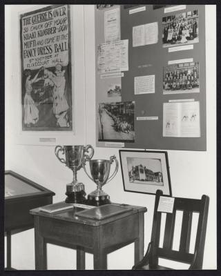 PHOTOGRAPH: MUSEUM DISPLAY, SCHOOL DISPLAY BOARD, WORLD WAR I POSTER, SCHOOL CUPS