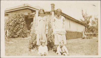 PHOTOGRAPH (DIGITAL COPY): TWO WOMEN AND TWO CHILDREN IN FRONT OF HOUSE, WHITE FAMILY