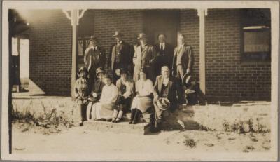 PHOTOGRAPH (DIGITAL COPY): LARGE GROUP ON THE STEPS IN FRONT OF A HOUSE, WHITE FAMILY