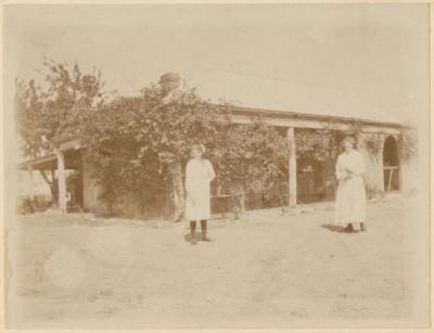 PHOTOGRAPH (DIGITAL COPY): TWO WOMEN IN FRONT OF HOMESTEAD, ABRAHAMS FAMILY