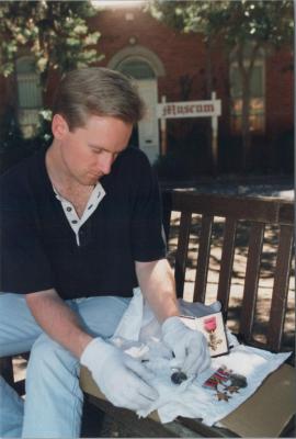 PHOTOGRAPH: STUDENT HANDLING MUSEUM OBJECTS