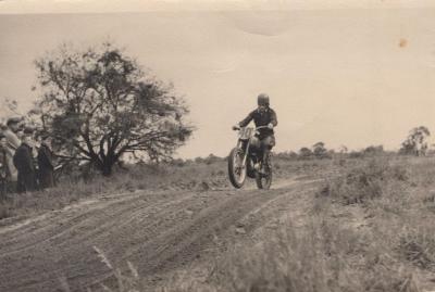 PHOTOGRAPH: VICTOR RICHARDSON RIDING A MOTORBIKE AT AERODROME