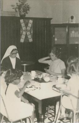 PHOTOGRAPH (COPY): NUNS AND CHILDREN SITTING AT A TABLE, ST. JOSEPH'S ORPHANAGE