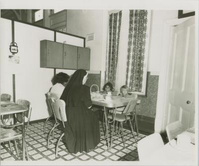 PHOTOGRAPH (COPY): NUNS AND CHILDREN SITTING AT A TABLE, ST. JOSEPH'S ORPHANAGE