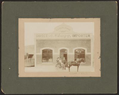 PHOTOGRAPH: SIMON CHUGG, IMPORTER, AND DAUGHTERS OUTSIDE CHUGG'S BUILDING