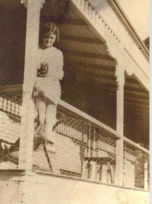 SHARKEY COLLECTION - YOUNG WOMAN WITH CAMERA ON VERANDAH